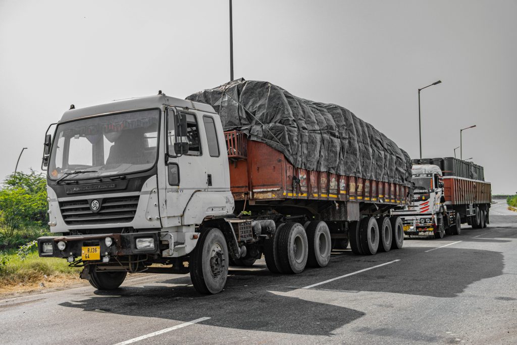 Heavy cargo trucks parked on a highway in Deeg, Uttar Pradesh, India, showcasing Indian logistics.